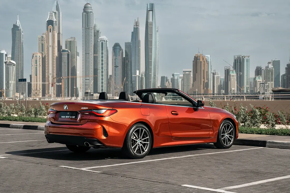 BMW 430i Convertible — rear three-quarter exterior beside the waterfront