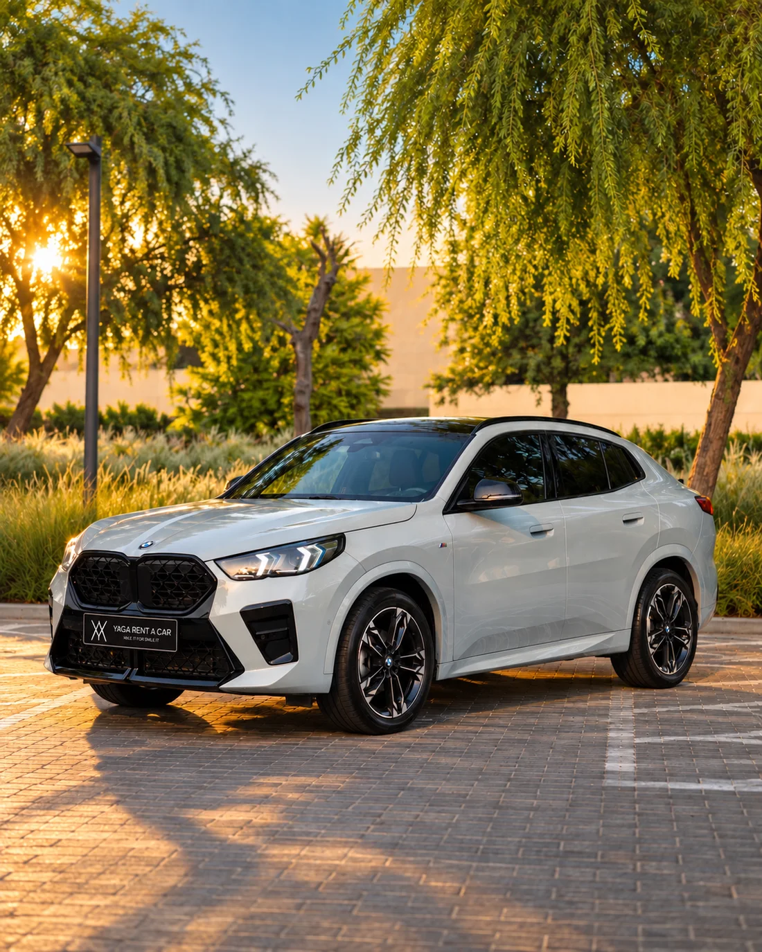 BMW X2 White — front three-quarter exterior under trees