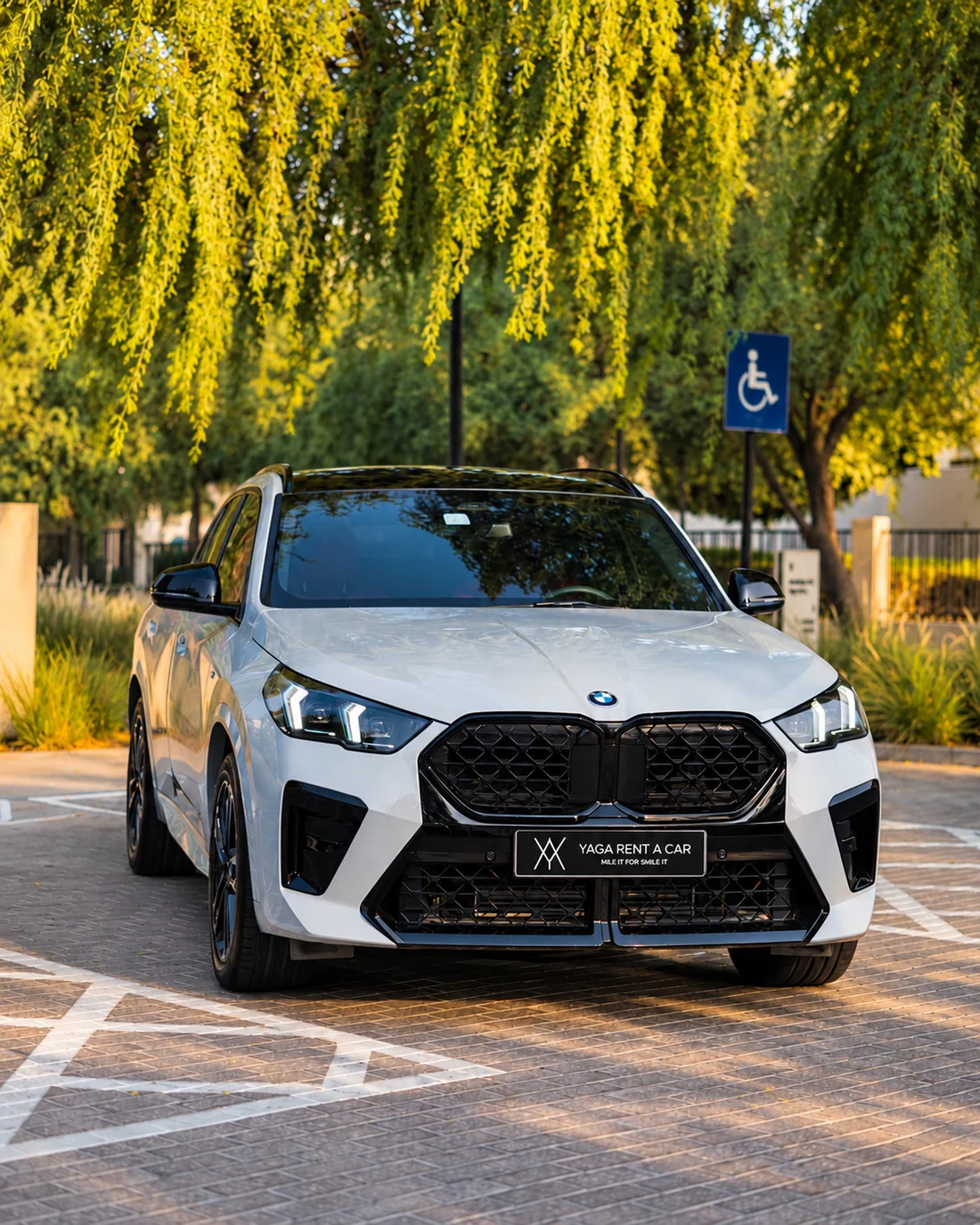 BMW X2 White — alternate front three-quarter exterior near trees