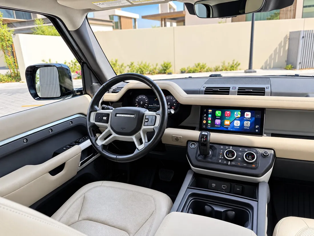 Land Rover Defender 7 Seats — beige front cabin and dashboard from the driver door