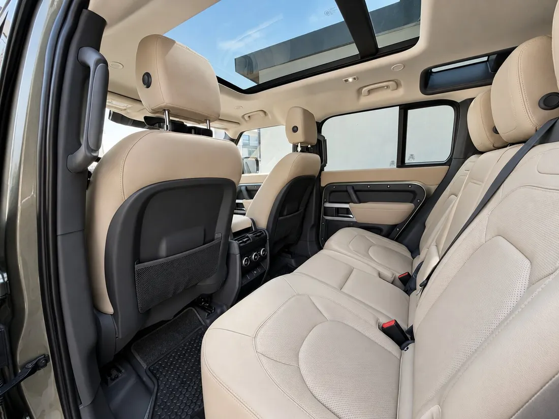 Land Rover Defender 7 Seats — second-row beige seating beneath the glass roof