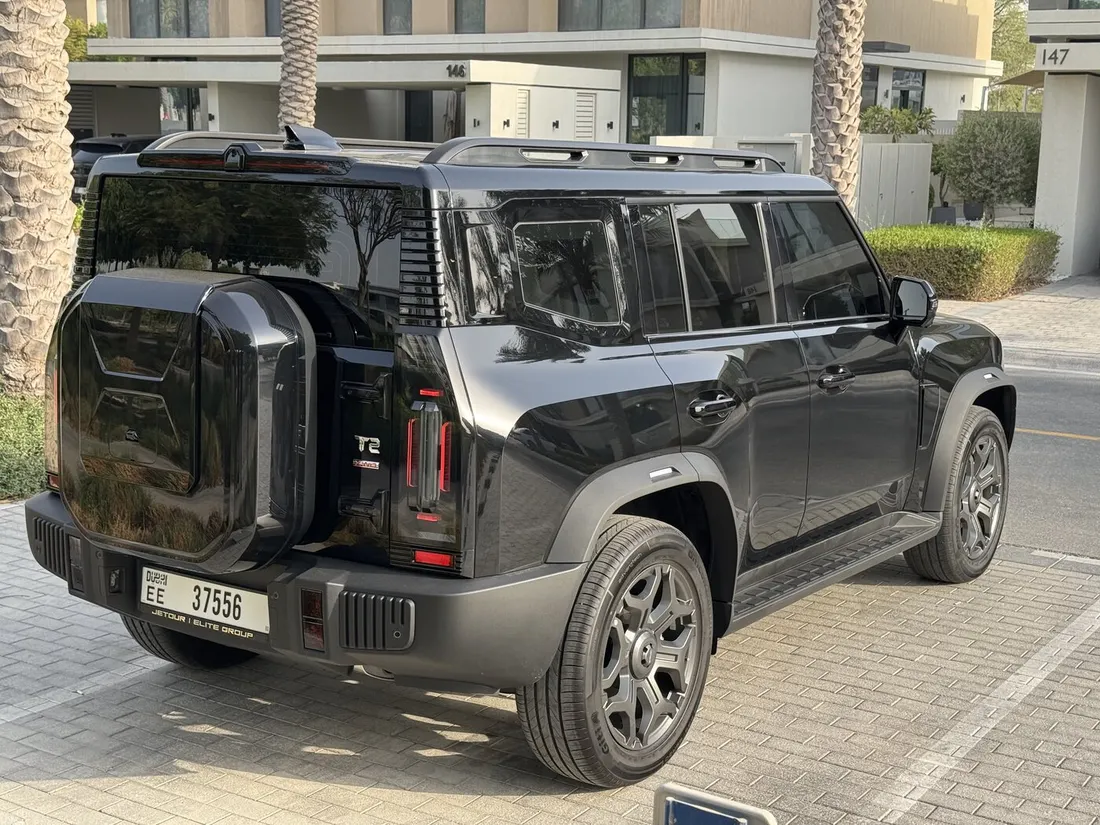 Jetour T2 Green Interior — rear three-quarter exterior beside a building